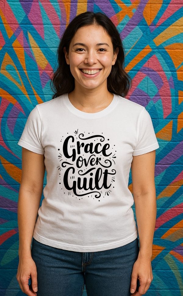
Smiling woman wearing white t-shirt from VerseWear by L’authority with bold hand-lettered text 'Grace Over Guilt' – Christian streetwear captured against colorful mural background
