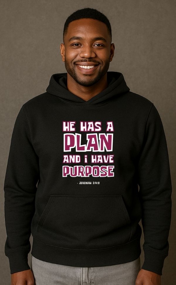 Smiling man wearing black VerseWear by L'authority Christian hoodie with bold text 'He Has a Plan and I Have Purpose – Jeremiah 29:11' – inspirational faith-based streetwear.