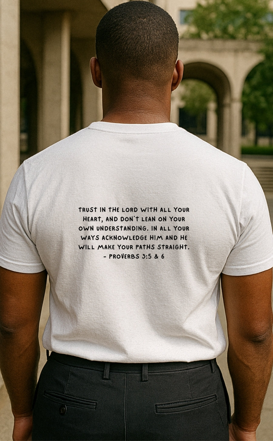 Back view of white t-shirt from VerseWear by L’authority featuring Proverbs 3:5–6 scripture – 'Trust in the Lord... and He shall direct your paths' – minimalist Christian fashion in urban setting.