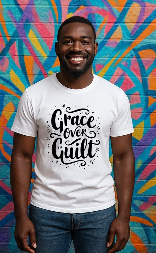 Smiling man wearing white t-shirt from VerseWear by L’authority with bold hand-lettered text 'Grace Over Guilt' – Christian streetwear captured against colorful mural background