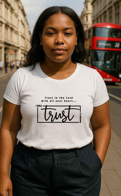 Young woman wearing white Christian t-shirt from VerseWear by L’authority with Proverbs 3:5 message – 'I Will Trust in the Lord with all your heart' – photographed on London street with red bus in background.