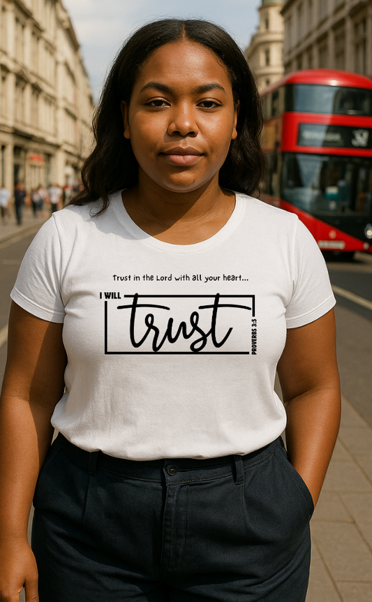 Young woman wearing white Christian t-shirt from VerseWear by L’authority with Proverbs 3:5 message – 'I Will Trust in the Lord with all your heart' – photographed on London street with red bus in background.
